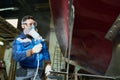 Worker painting boats in yacht workshop Royalty Free Stock Photo