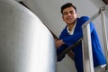 Low angle portrait of worker standing by storage tank Royalty Free Stock Photo