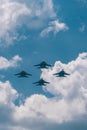 Low angle of the powerful military fighter jets flying in the cloudy blue sky