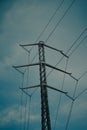 Low angle of a pylon tower supporting electrical cables against the evening sky Royalty Free Stock Photo