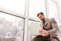 Low angle of serious businessman using laptop