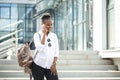 African american woman with backpack walking outdoor and talking on mobile phone Royalty Free Stock Photo