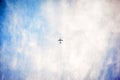 Low angle shot of an airplane flying high in the sky with pure white clouds Royalty Free Stock Photo