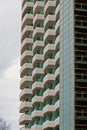 Low angle shot of balconies of a high-rise building with blue glasses under the light