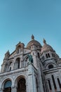 Low angle shot of The Basilica of the Sacred Heart of Paris under a blue sky in France