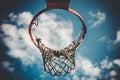 Low angle shot of a basketball ring with torn net against a blurry cloudy sky Royalty Free Stock Photo
