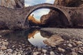 Low angle shot of a beautiful stone arch bridge in Zagori, Greece with a pile of water underneath it