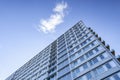 Low angle shot of a big building under a cloud in the beautiful blue sky Royalty Free Stock Photo