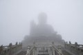 Low angle shot of Buddha statue hidden in mist on top of Po Lin monastery Lantau, Hong Kong