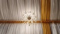 Low angle shot of a chandelier in the ceiling with white and yellow textiles Royalty Free Stock Photo