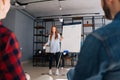 Low-angle shot of cheerful young business lady finishing presentation on whiteboard. Royalty Free Stock Photo