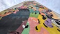 Low-angle shot of a colorful street art wall with abstract pictures up to the sky