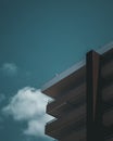 Low angle shot of corner balconies of modern apartment building on blue cloudy sky background Royalty Free Stock Photo