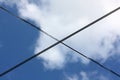 Low angle shot of crossed wires under the cloudy sky