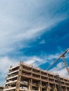 Low angle shot of elevating crane and building construction site Royalty Free Stock Photo