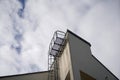 Low angle shot of an emergency exit ladder of a tall building against a cloudy sky Royalty Free Stock Photo