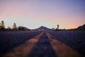 Low angle shot of an empty road with mountains and a clear sky in the background Royalty Free Stock Photo