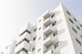 Low angle shot of a facade of a white modern building under a blue clear sky Royalty Free Stock Photo