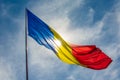 Low angle shot of the flag of Romania waving under the sunny bright sky