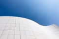 Low-angle shot of a futuristic white building on a clear blue sky