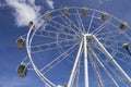 Low angle shot of a giant Ferris wheel  under the blue cloudy sky Royalty Free Stock Photo