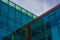 Low angle shot of glass modern building against a blue sky Royalty Free Stock Photo