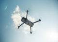 Low angle shot of a gray quadcopter drone with a camera in a blue sky Royalty Free Stock Photo