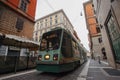 Low angle shot of a green 14 tram in the streets of Rome, Italy