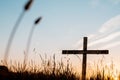 Low angle shot of a handmade wooden cross in a grassy field with a beautiful sky in the background Royalty Free Stock Photo