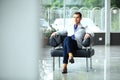 Low angle shot of a handsome young businessman in a stylish modern office space with large windows. Royalty Free Stock Photo