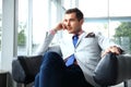 Low angle shot of a handsome young businessman in a stylish modern office space with large windows. Royalty Free Stock Photo