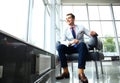 Low angle shot of a handsome young businessman in a stylish modern office space with large windows. Royalty Free Stock Photo