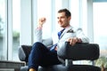 Low angle shot of a handsome young businessman in a stylish modern office space with large windows. Royalty Free Stock Photo