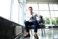 Low angle shot of a handsome young businessman in a stylish modern office space with large windows. Royalty Free Stock Photo