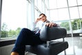 Low angle shot of a handsome young businessman in a stylish modern office space with large windows. Royalty Free Stock Photo