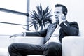 Low angle shot of a handsome young businessman in a stylish modern office space with large windows, talking on mobile Royalty Free Stock Photo