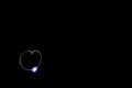 Low angle shot of a heart-shaped blue light in a black background