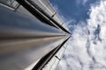 Low angle shot of a high modern office building against the cloudy sky Royalty Free Stock Photo