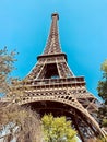 Low angle shot of the historic Eiffel Tower in Paris, France set against a vivid blue sky