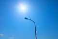 Low angle shot of a lamppost with the sunny blue sky in the background Royalty Free Stock Photo
