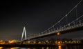 Low angle shot of a large bridge going over the water at night Royalty Free Stock Photo