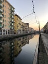 Low angle shot of large buildings in the water canal in navigli district Royalty Free Stock Photo