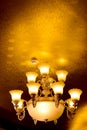 Low-angle shot of a luxurious vintage chandelier hanging on a ceiling,with many lightbulbs turned on
