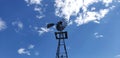 Low-angle shot of the metal pinwheel against a blue sky