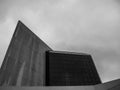 Low angle shot of a modern building with glass panels against a cloudy sky in grayscale Royalty Free Stock Photo