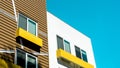 Low angle shot of modern concrete brown and white buildings with yellow balconies Royalty Free Stock Photo