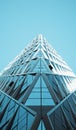 Low angle shot of a modern glass building in the blue sky background Royalty Free Stock Photo