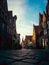 Low-angle shot of a narrow street at sunrise with a blue sky in the background, Cobblestone, Germany