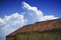 Low angle shot of old roof tiles of a building with a cloudy blue sky in the background Royalty Free Stock Photo