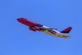 Low angle shot of a pink Wizz Air plane flying in a blue sky Royalty Free Stock Photo